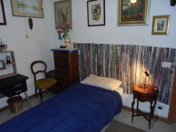 Foto camera singola con frigo e TV  posteggio auto.