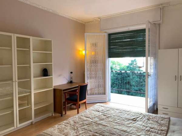 Foto Stanza ampia arredata con balcone